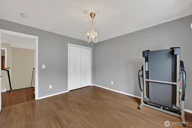 24213 41st Ave E, Spanaway, WA 98387 - exercise area with a chandelier, wood finished floors, and baseboards