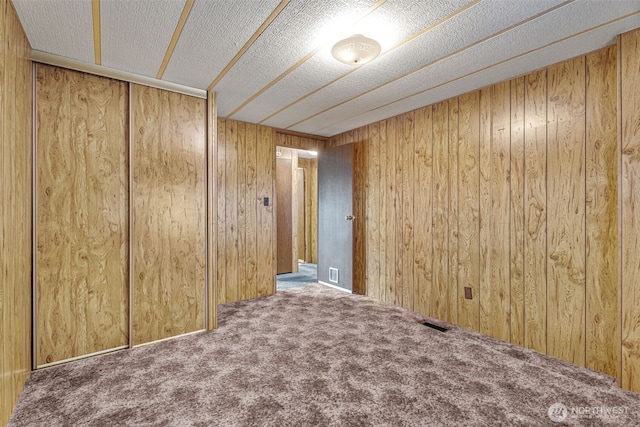 7300 32nd Ave NE Unit 5, Olympia, WA 98516 - unfurnished room with carpet, wooden walls, and a textured ceiling