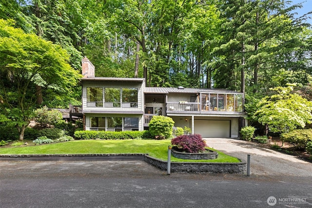 5019 E Mercer Way, Mercer Island, WA 98040 - view of front of house with concrete driveway, an attached garage, a chimney, metal roof, and a front yard