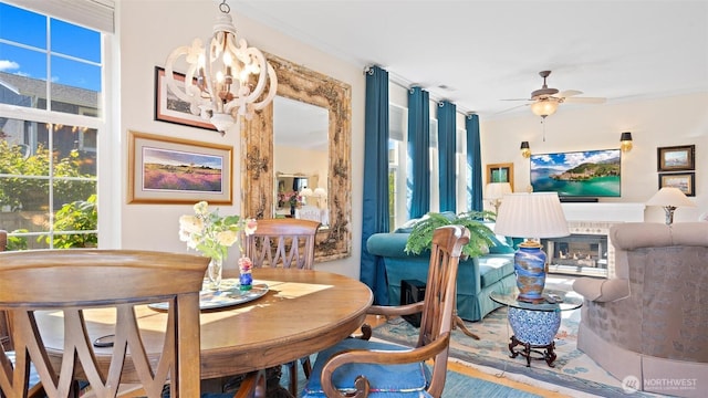 221 NE Honey Locust Ct, Poulsbo, WA 98370 - dining space featuring ceiling fan, a glass covered fireplace, a chandelier, and ornamental molding