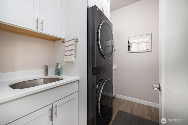 742 Parkland Loop, Sedro Woolley, WA 98284 - laundry room with stacked washer / dryer, cabinet space, wood finished floors, and baseboards