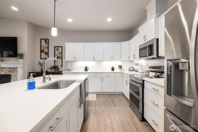 742 Parkland Loop, Sedro Woolley, WA 98284 - kitchen featuring appliances with stainless steel finishes, a sink, light countertops, decorative backsplash, and light wood finished floors