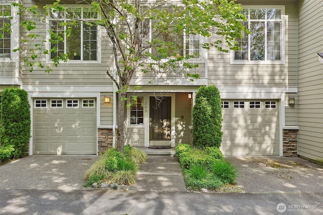 11800 SE 4th Pl Unit 203, Bellevue, WA 98005 - view of front facade with a garage, driveway, and stone siding
