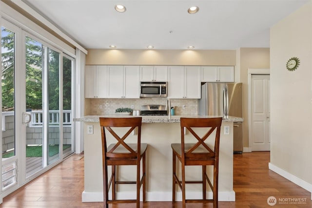 11800 SE 4th Pl Unit 203, Bellevue, WA 98005 - kitchen with stainless steel appliances, decorative backsplash, white cabinetry, and recessed lighting