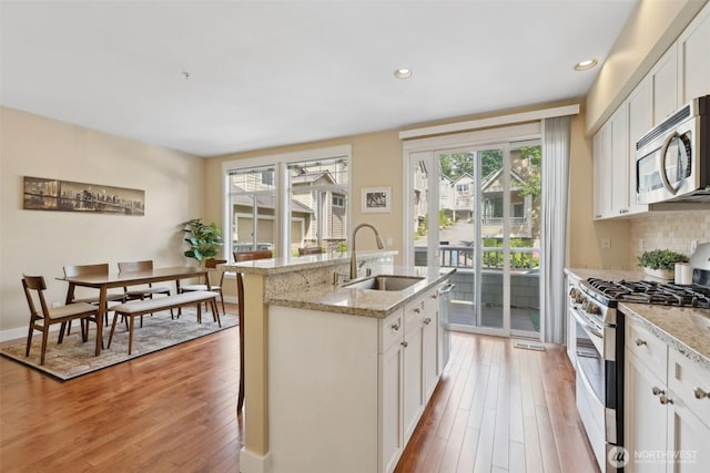 11800 SE 4th Pl Unit 203, Bellevue, WA 98005 - kitchen featuring a sink, appliances with stainless steel finishes, healthy amount of natural light, light wood-style floors, and recessed lighting