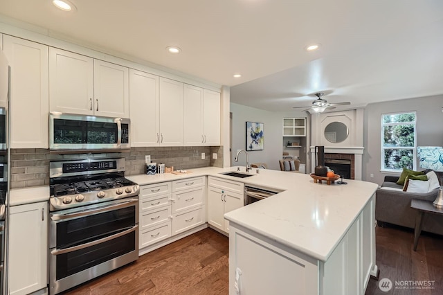 3402 174th Pl SE, Bothell, WA 98012 - kitchen featuring stainless steel appliances, a sink, a peninsula, open floor plan, and dark wood-type flooring