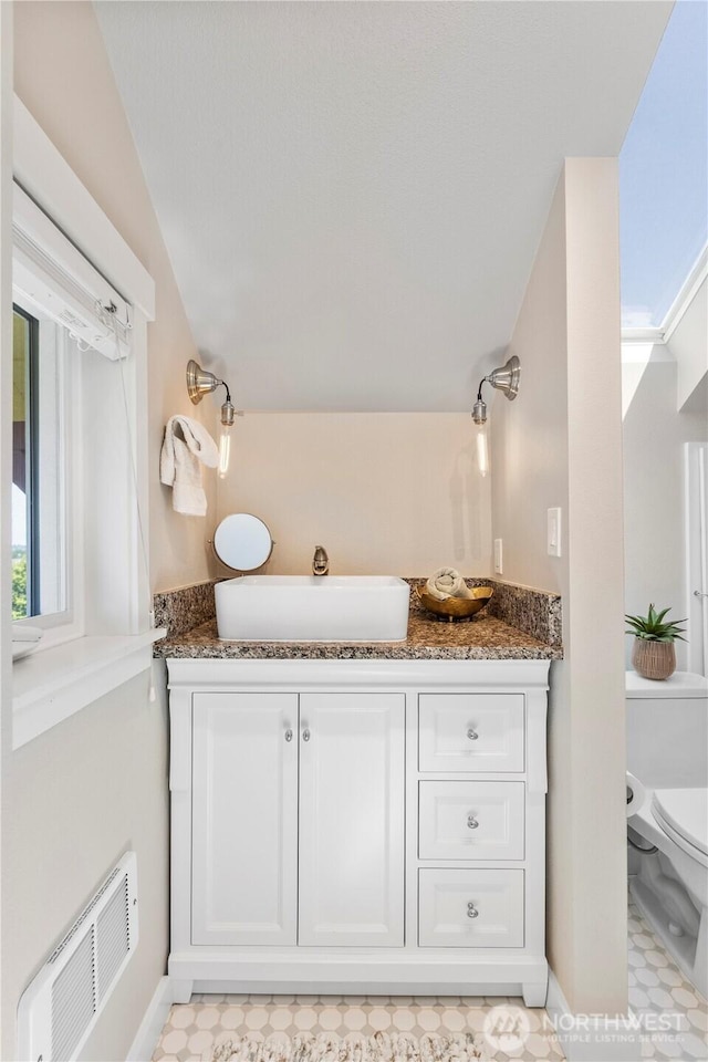 1220 SW Orchard St, Seattle, WA 98106 - bathroom featuring toilet, vanity, baseboards, tile patterned floors, and lofted ceiling