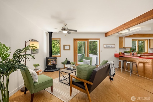 32227 Old Hansville Rd NE, Kingston, WA 98346 - living room with a wood stove, beamed ceiling, plenty of natural light, ceiling fan, and light wood-style flooring
