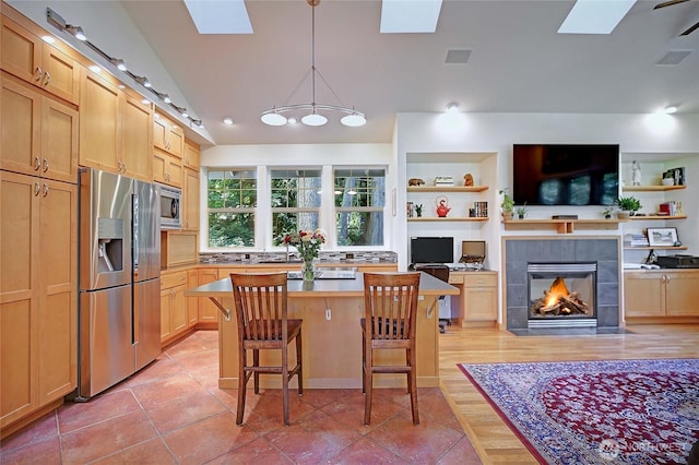 1577 Arrowhead Beach Rd, Camano Island, WA 98282 - kitchen with stainless steel appliances, a skylight, light tile patterned floors, and a tiled fireplace