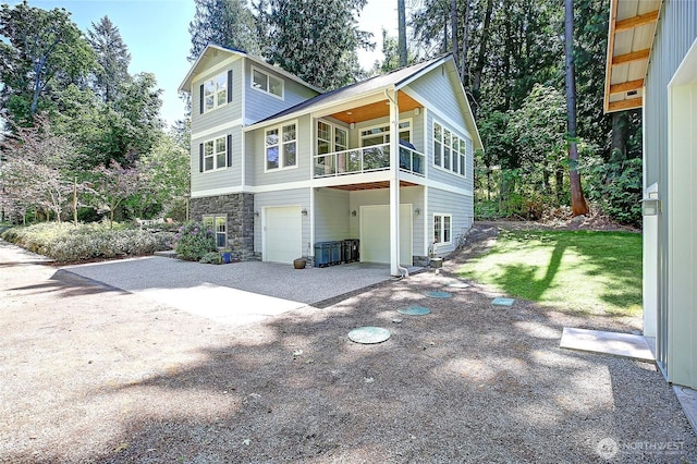 1577 Arrowhead Beach Rd, Camano Island, WA 98282 - view of front of house featuring an attached garage, concrete driveway, a balcony, and stone siding