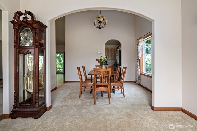 3210 275th St NE, Arlington, WA 98223 - dining area with light carpet, arched walkways, baseboards, and a chandelier