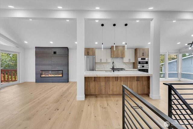 12816 130th Ct NE, Kirkland, WA 98034 - kitchen with stainless steel appliances, light wood-style flooring, light countertops, open floor plan, and recessed lighting