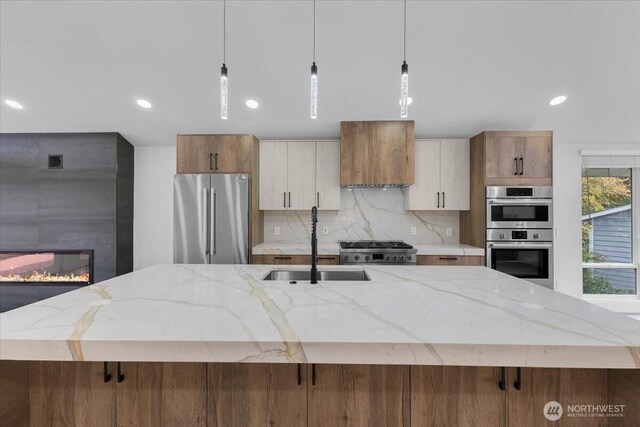 12816 130th Ct NE, Kirkland, WA 98034 - kitchen with stainless steel appliances, a sink, custom exhaust hood, a spacious island, and a large fireplace