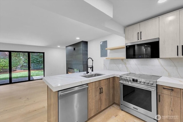 12816 130th Ct NE, Kirkland, WA 98034 - kitchen with appliances with stainless steel finishes, a sink, a peninsula, light wood-style flooring, and open shelves