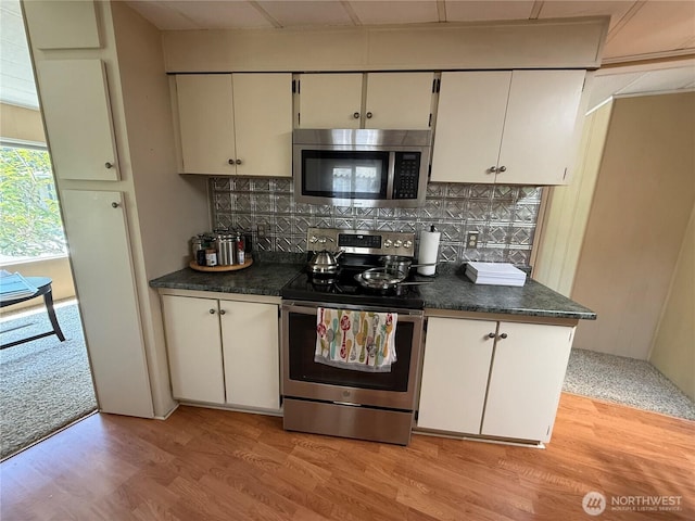 1415 84th St SE Unit 196, Everett, WA 98208 - kitchen with stainless steel appliances, dark countertops, backsplash, and light wood finished floors