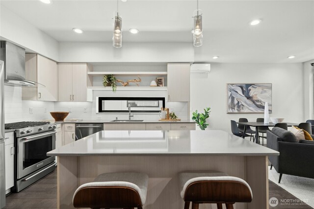 3219 California Ave SW Unit B, Seattle, WA 98116 - kitchen featuring open shelves, appliances with stainless steel finishes, wall chimney exhaust hood, a sink, and a breakfast bar