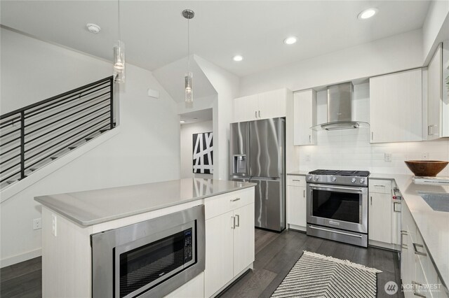 3219 California Ave SW Unit B, Seattle, WA 98116 - kitchen featuring stainless steel appliances, wall chimney range hood, dark wood-type flooring, light countertops, and white cabinets