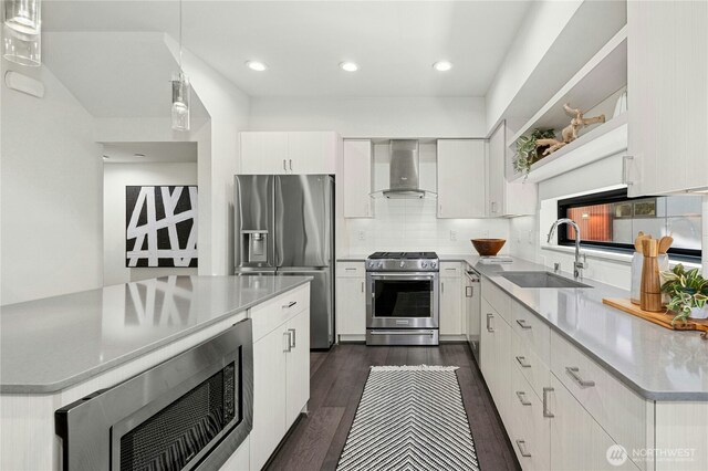 3219 California Ave SW Unit B, Seattle, WA 98116 - kitchen with wall chimney range hood, appliances with stainless steel finishes, a sink, white cabinetry, and light countertops
