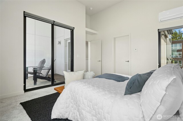 3219 California Ave SW Unit B, Seattle, WA 98116 - bedroom featuring a wall unit AC, access to outside, carpet floors, baseboards, and a towering ceiling