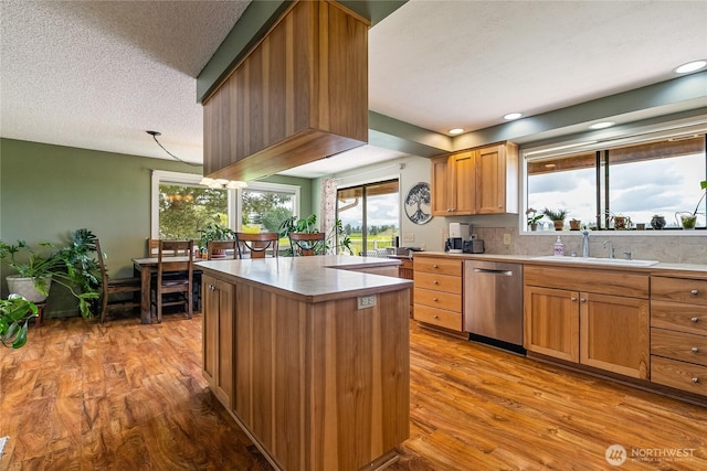 405 E Wiser Lake Rd, Lynden, WA 98264 - kitchen featuring stainless steel dishwasher, wood finished floors, a kitchen island, a sink, and backsplash