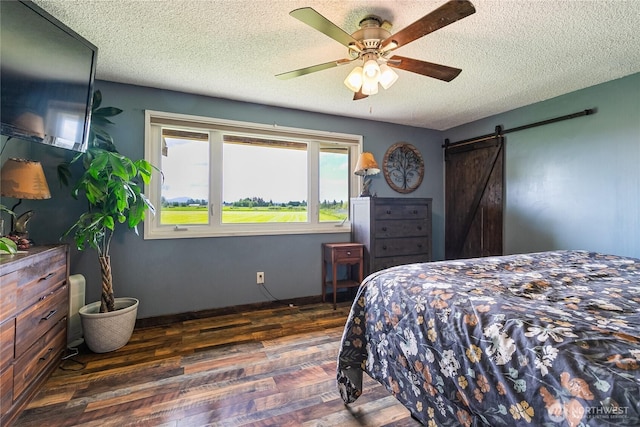 405 E Wiser Lake Rd, Lynden, WA 98264 - bedroom with a barn door, wood finished floors, a textured ceiling, a ceiling fan, and baseboards