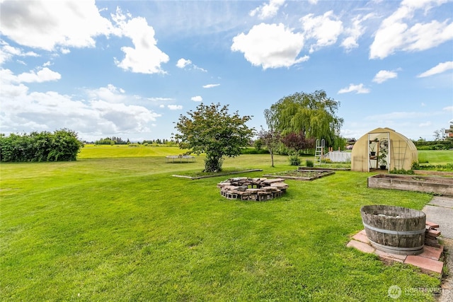 405 E Wiser Lake Rd, Lynden, WA 98264 - view of grassy yard with a vegetable garden, an exterior structure, an outdoor fire pit, and an outdoor structure