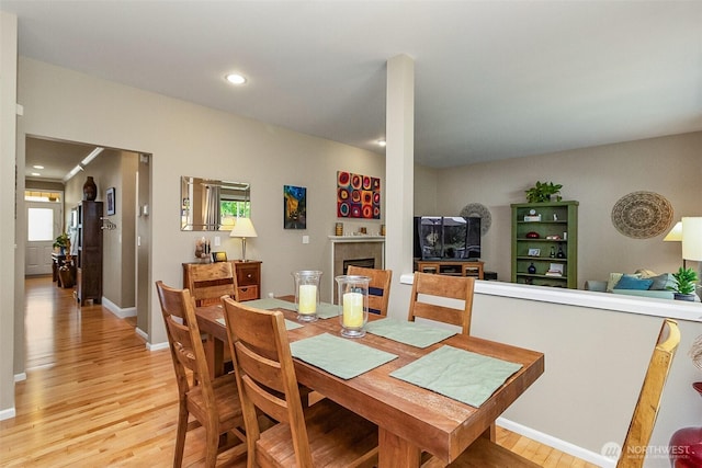7623 152nd St SE, Snohomish, WA 98296 - dining area featuring light wood-type flooring, a fireplace, and baseboards