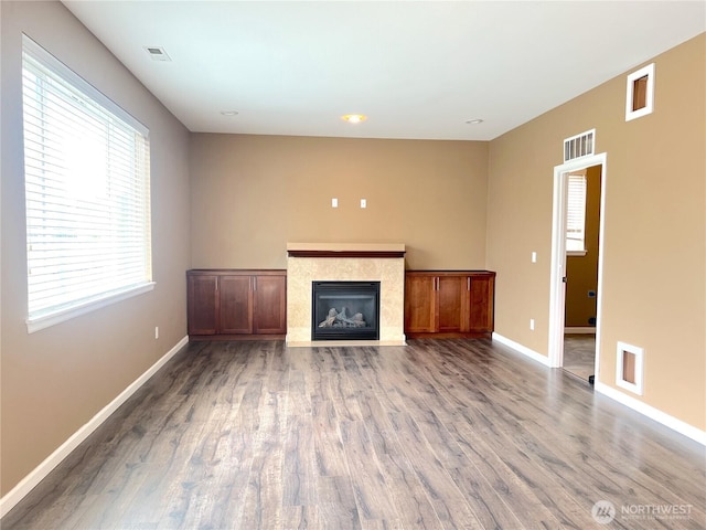 10027 SE Dotson St SE, Yelm, WA 98597 - unfurnished living room featuring baseboards, a tile fireplace, and wood finished floors