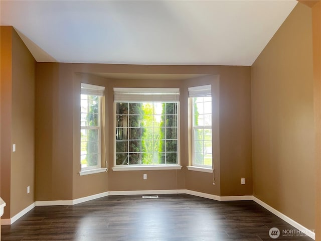 10027 SE Dotson St SE, Yelm, WA 98597 - spare room featuring dark wood-type flooring and baseboards