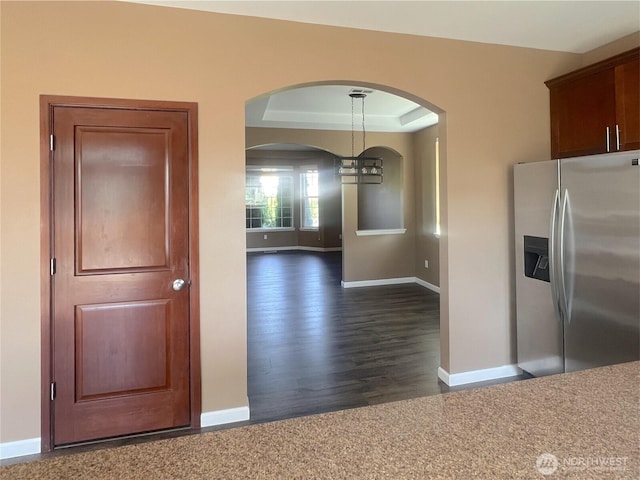 10027 SE Dotson St SE, Yelm, WA 98597 - kitchen with stainless steel fridge with ice dispenser, arched walkways, baseboards, dark wood-style floors, and a chandelier