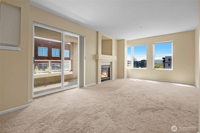 4343 Roosevelt Way NE Unit 401, Seattle, WA 98105 - unfurnished living room with healthy amount of natural light, carpet flooring, and a glass covered fireplace
