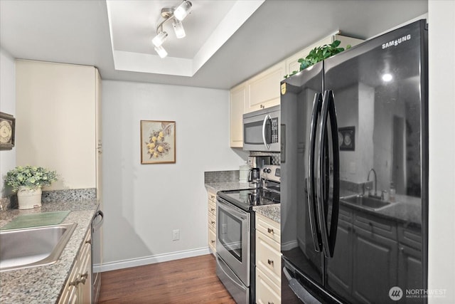15512 Country Club Dr Unit B25, Mill Creek, WA 98012 - kitchen featuring stainless steel appliances, a raised ceiling, dark wood-style floors, baseboards, and cream cabinets