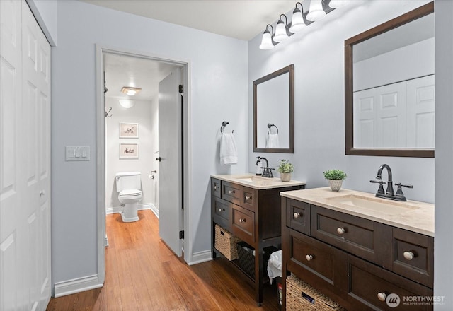 15512 Country Club Dr Unit B25, Mill Creek, WA 98012 - full bath featuring wood finished floors, two vanities, baseboards, and toilet