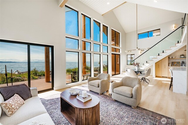 4489 Sucia Dr, Ferndale, WA 98248 - living room featuring high vaulted ceiling, stairway, healthy amount of natural light, a water view, and wood ceiling with exposed beams