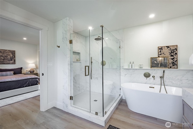 4489 Sucia Dr, Ferndale, WA 98248 - bathroom with wood finished floors, a marble finish shower, ensuite bath, a soaking tub, and recessed lighting