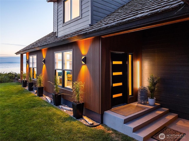 4489 Sucia Dr, Ferndale, WA 98248 - exterior entry at dusk featuring a lawn and a water view
