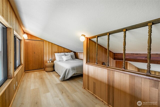 4489 Sucia Dr, Ferndale, WA 98248 - bedroom with vaulted ceiling, wood walls, and light wood-type flooring