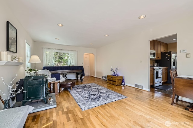 12019B 25th Ave NE, Seattle, WA 98125 - living room featuring arched walkways, light wood-style flooring, recessed lighting, and baseboards