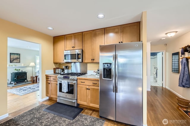 12019B 25th Ave NE, Seattle, WA 98125 - kitchen featuring stainless steel appliances, a wood stove, dark wood-style floors, recessed lighting, and light countertops