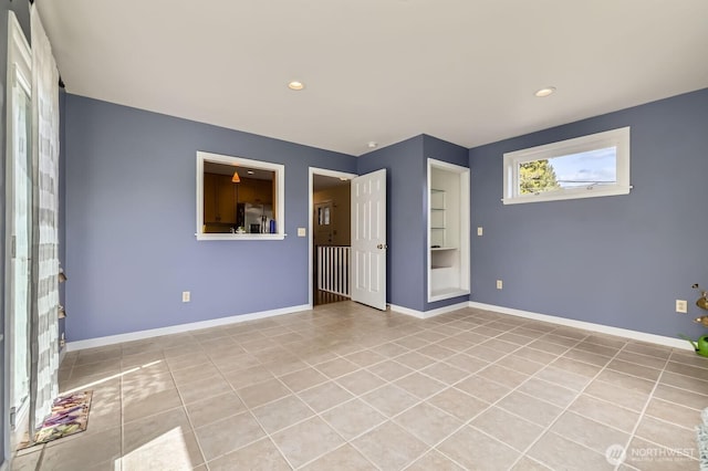 12019B 25th Ave NE, Seattle, WA 98125 - empty room with light tile patterned floors, recessed lighting, built in shelves, and baseboards