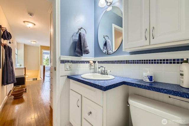 12019B 25th Ave NE, Seattle, WA 98125 - bathroom with toilet, wood-type flooring, vanity, and backsplash