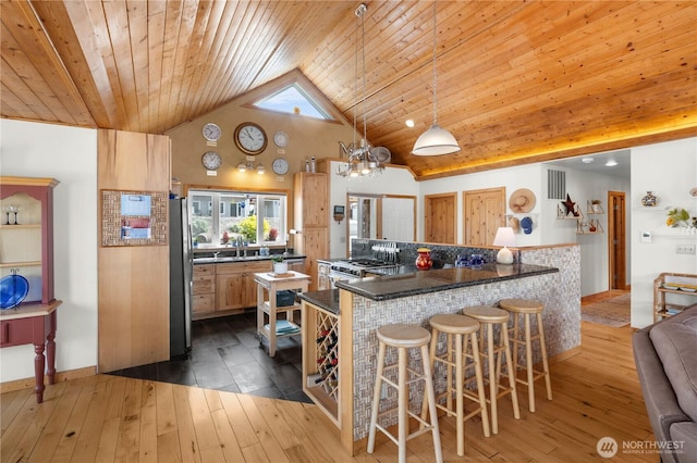 418 Summer Pl SW, Mattawa, WA 99349 - kitchen with freestanding refrigerator, wooden ceiling, healthy amount of natural light, dark countertops, and a breakfast bar area