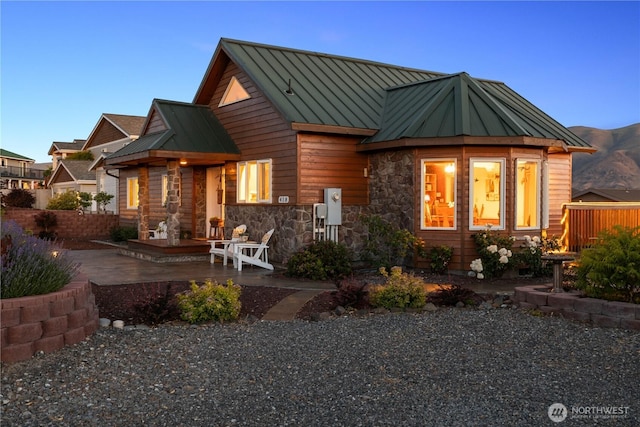 418 Summer Pl SW, Mattawa, WA 99349 - view of front of property featuring a standing seam roof, a patio area, stone siding, and metal roof