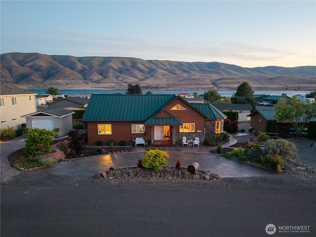 418 Summer Pl SW, Mattawa, WA 99349 - view of front of house with curved driveway, a standing seam roof, a mountain view, metal roof, and a garage