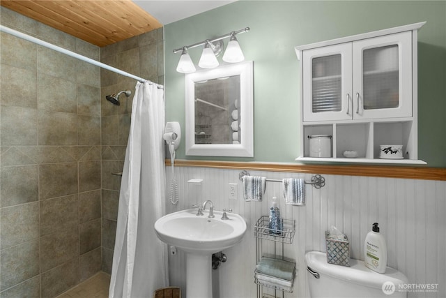 418 Summer Pl SW, Mattawa, WA 99349 - bathroom featuring toilet, tiled shower, wainscoting, and a sink
