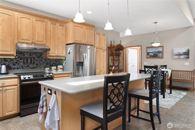 252 Mariners Dr, Sequim, WA 98382 - kitchen with appliances with stainless steel finishes, under cabinet range hood, tasteful backsplash, a kitchen bar, and a center island