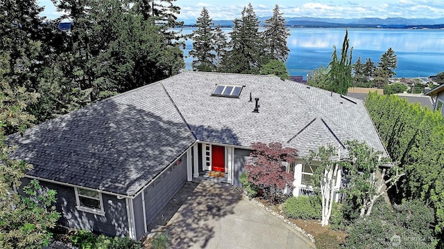 1351 Crestview Dr, Camano Island, WA 98282 - view of front facade with roof mounted solar panels, a water view, concrete driveway, and an attached garage