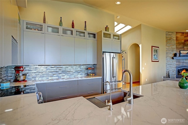 1351 Crestview Dr, Camano Island, WA 98282 - kitchen featuring stainless steel appliances, a sink, tasteful backsplash, light stone countertops, and lofted ceiling