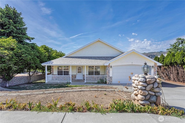 1718 6th St SE, East Wenatchee, WA 98802 - view of front of home featuring a porch, stone siding, a garage, concrete driveway, and a shingled roof