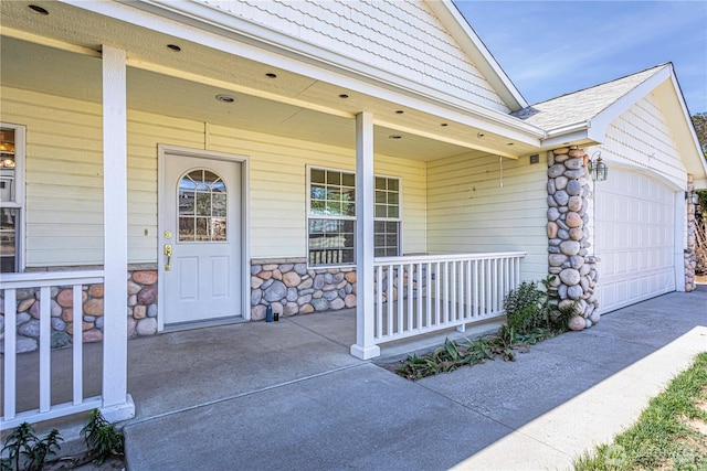 1718 6th St SE, East Wenatchee, WA 98802 - view of exterior entry featuring a porch, stone siding, driveway, an attached garage, and a shingled roof